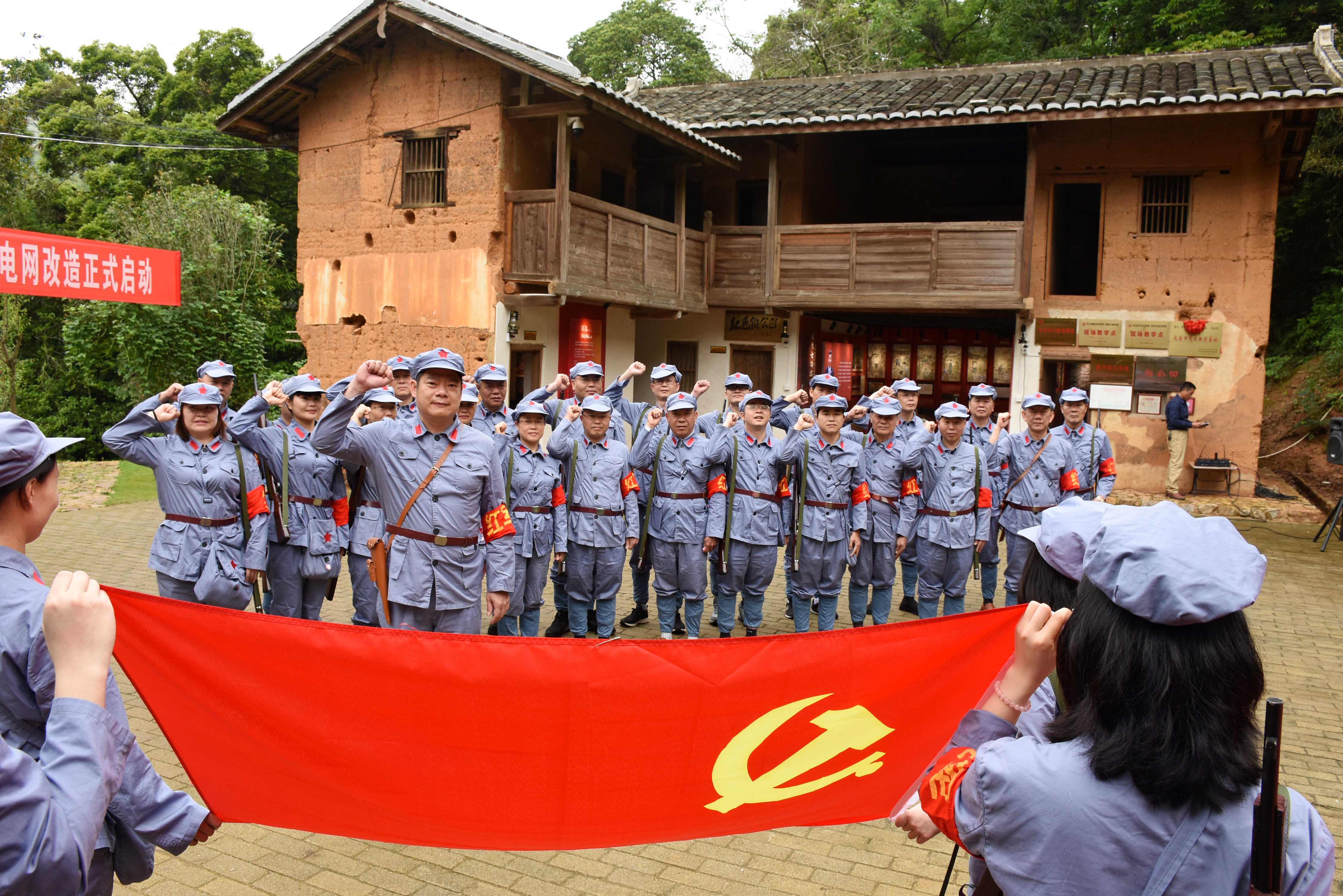 在中央红色交通线入闽第一站伯公凹交通站,全体党员面向党旗重温入党